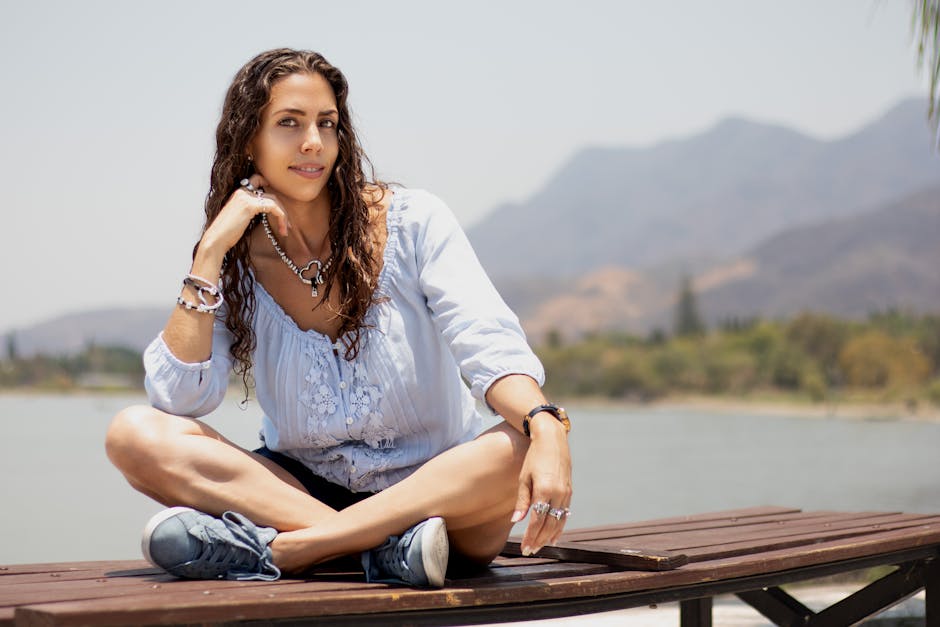 Woman practicing a peaceful yoga pose on a wooden pier next to a serene lake
